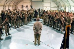 military personnel meeting inside a fabric structure